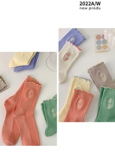 Detail of cotton crew socks with tulip embroidery and ruffled edges in various colors