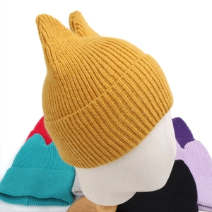 Detail of colorful knitted cat ear hats featuring vertical ribbing and turnover brims