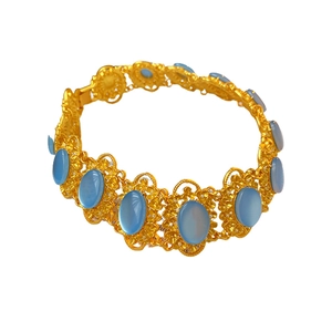 Vintage gold necklace with ornate filigree design and oval blue gemstones on white background