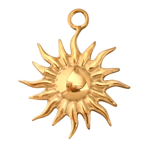 Macro shot of gold sun charm pendant with radiating wavy rays for DIY jewelry making