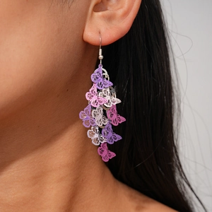 Detail of bohemian butterfly tassel earrings with purple and pink hollow metal charms