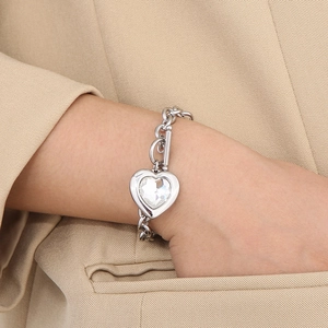 Close-up of heart charm bracelet with crystal and OT toggle clasp on beige fabric