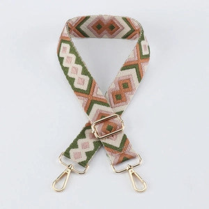 Detail of adjustable woven bag strap with geometric diamond pattern and gold metal hooks