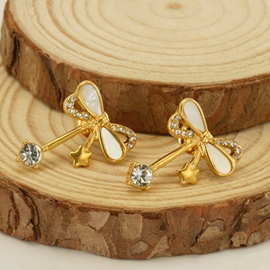 Gold-plated bowknot earrings with white shell inlay, star pendants, and sparkling crystals