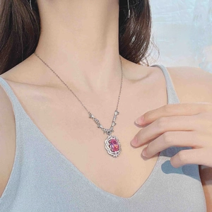Close-up of luxury pink sapphire pendant necklace with double halo diamond setting
