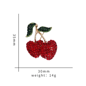 Detail view of cherry brooch with red rhinestones measuring 35mm by 30mm size