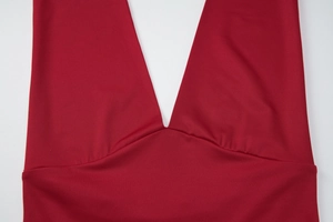 Dettaglio cucitura dello scollo profondo a V su top rosso aderente senza schiena da donna