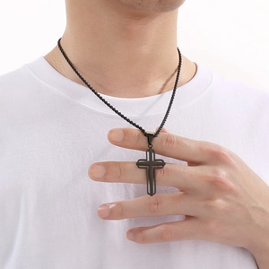 Close-up of man wearing a minimalist black hollowed-out stainless steel cross pendant
