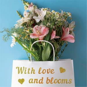 Detail of glitter gold heart and alphabet stickers on white floral gift bag