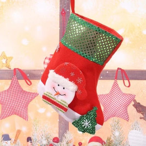 Detail of red Christmas stocking with snowman patch, green sequins, and festive textures