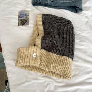 Detail of knit balaclava hood with rustic texture and white button fastener