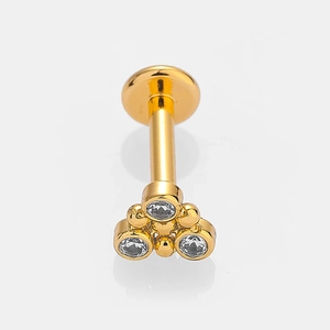 Macro view of gold stainless steel labret stud with a three-zircon cluster design