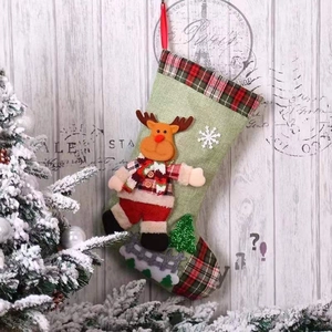 Detail of green Christmas stocking with 3D plush reindeer on wooden background