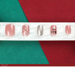 Detail of Christmas press-on nails with pink glitter, polka dots and reindeer nail art