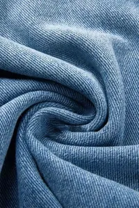 Gros plan du tissu denim bleu montrant le tissage sergé détaillé et la texture fine