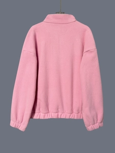 Close-up of pink polar fleece sweatshirt fabric texture with elastic cuffs and hem