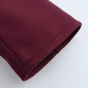 Close-up of wine red wool coat cuff showing high-quality stitching and fabric texture