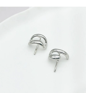 Close-up of minimalist silver geometric curved hair hooks on a white tray