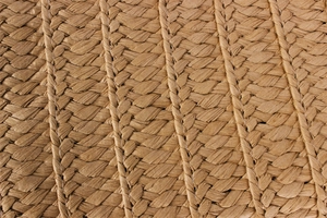 Close-up of natural woven straw texture and intricate handmade stitching on the tote bag