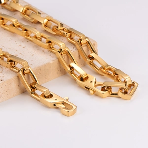 Minimalist gold-tone stainless steel square link chain necklace displayed on stone pedestal