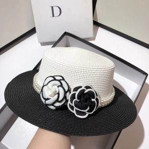 Detail of luxury straw hat featuring exquisite camellia flowers and pearl chain trim