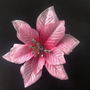 Detail of pink artificial poinsettia flower with silver glitter edges and yellow center