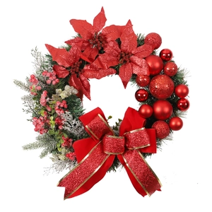 Christmas wreath with red poinsettias, shiny baubles, and large bow on evergreen pine