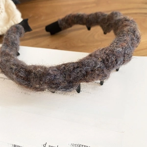 Detail of knit wavy headband with non-slip teeth on vintage book backdrop