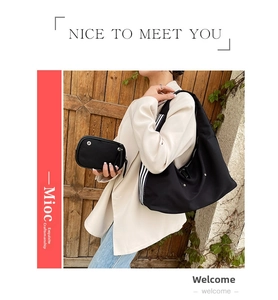 Detailed view of black nylon hobo bag set with striped shoulder strap and small pouch