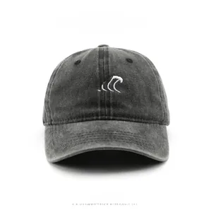 Close-up of three-wave white embroidery on washed dark grey cotton baseball cap