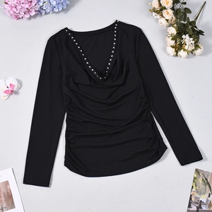 Close-up of black long-sleeve top featuring silver studs along the deep V-neckline