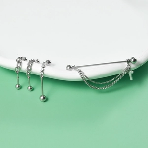Detail of silver stainless steel industrial barbell with cross pendant and zircon studs