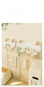 Detail showing wall-mounted cream plug organizer with wooden hooks in kitchen setting