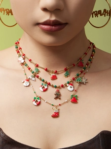 Détail d'un ensemble de bijoux de Noël dorés avec breloques émaillées et créoles Happy