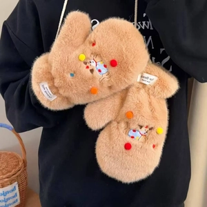 Detail of plush camel mittens with cute reindeer embroidery and soft decorative pom-poms