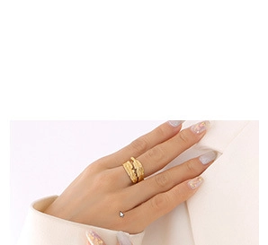 Close-up of double-layered gold ring with textured surface on model wearing white suit