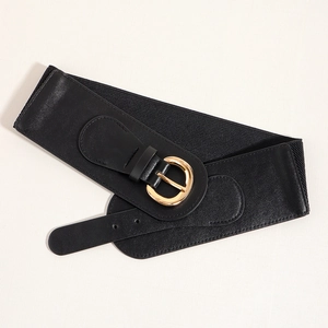 Close-up of women's black wide elastic belt with a polished gold round buckle detail