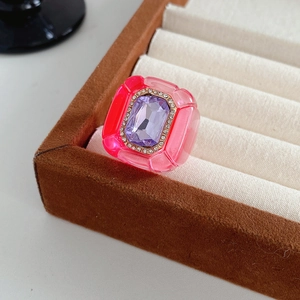 Détail d'une bague vintage en résine avec pierre violette dans un écrin à bijoux