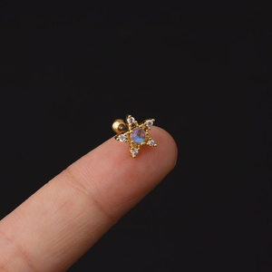 Golden star-shaped surgical steel earring with blue gemstone and white cubic zirconia accents