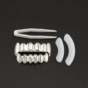 Set de grillz hip hop argentés avec pince et barres de silicone sur fond noir profond