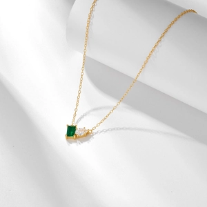 Detail of s925 silver gold necklace with emerald-cut green stone and teardrop zircon