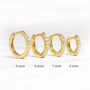 Detalle de pendientes de aro dorados con circonitas en tamaños de 6mm a 9mm