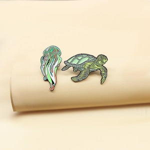Enamel brooch set featuring a green turtle and jellyfish with intricate alloy details
