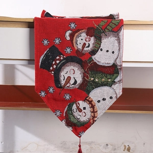 Detail showing red Christmas table runner with snowman patterns and hanging tassel