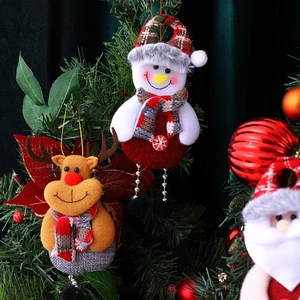 Christmas tree ornaments featuring Santa, snowman, and reindeer on a green branch