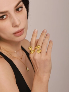 Macro shot of irregular 18K gold plated stainless steel double ring on model's hand