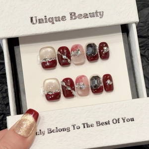Short square berry red press-on nails with champagne cat-eye glitter and rhinestones