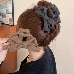 Close-up of elegant fabric bow hair claw clips in dark grey and coffee brown colors