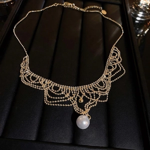 Vintage 24K gold plated lace necklace with white pearl pendant on black leather display