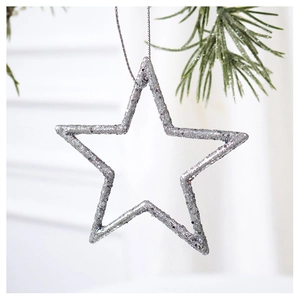 Close-up of sparkling silver star ornament with glitter hanging on green pine branch